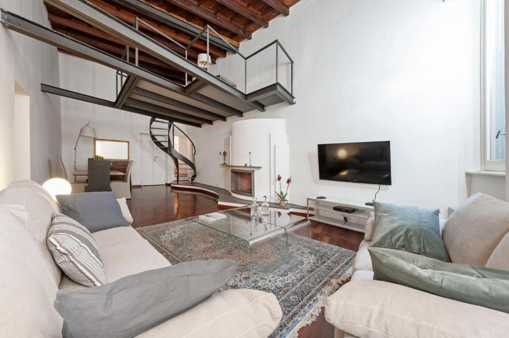 a living room with a couch and a tv at Antique-Modern Flat by Navona Square in Rome