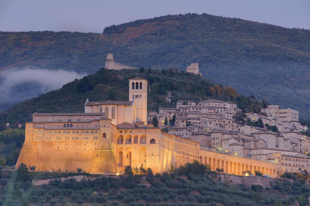 un gran edificio en la cima de una montaña en Albergo La Rocca en Assisi