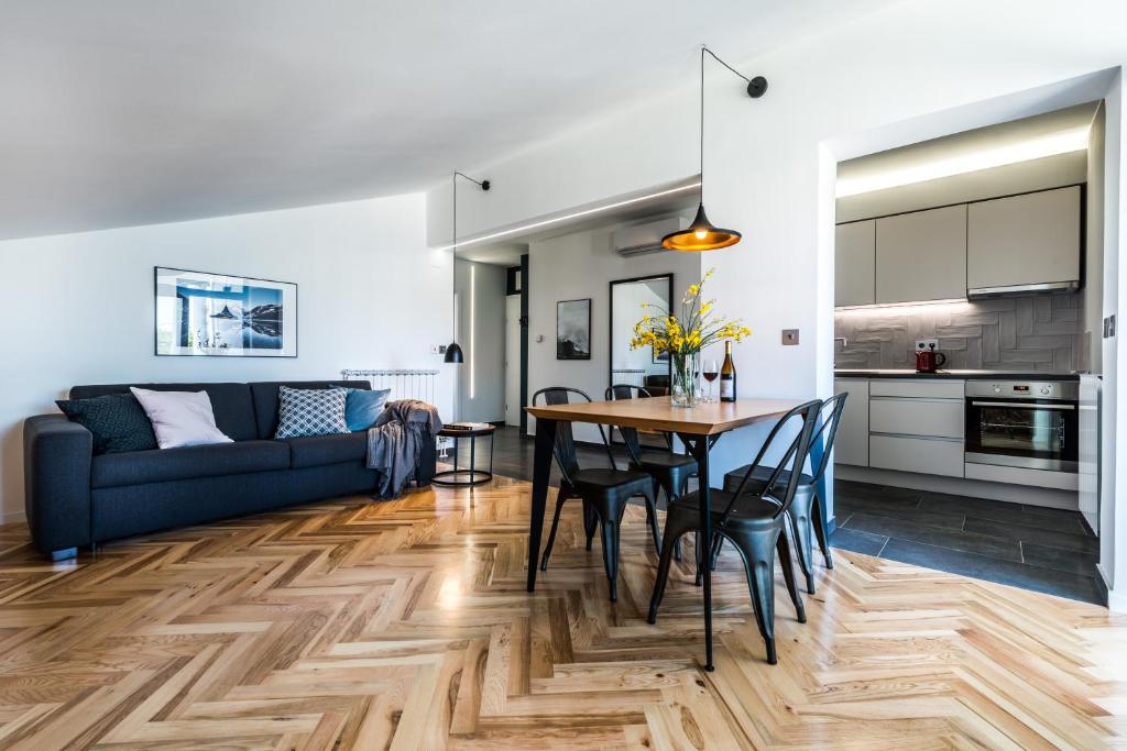 a kitchen and living room with a table and chairs at The Park Apartments in Zadar