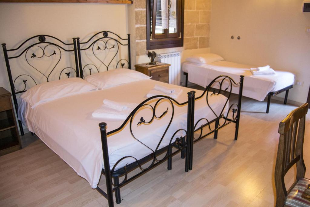 um quarto com 2 camas e lençóis brancos em Salento Casevecchie em Sogliano Cavour