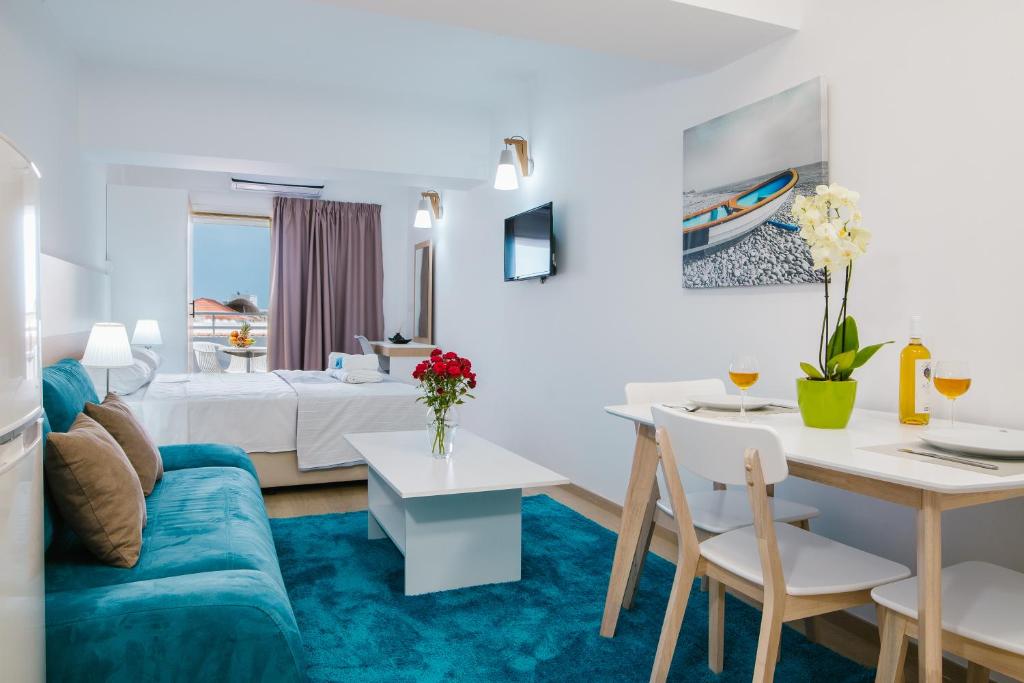 ein Wohnzimmer mit einem blauen Sofa und einem Esszimmer in der Unterkunft Stephanie Studios in Larnaka