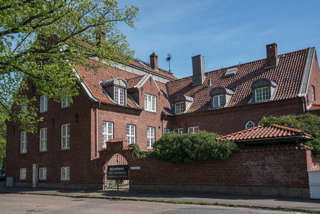 un grand bâtiment en briques rouges avec un toit rouge dans l'établissement Halmstad Hotell & Vandrarhem Kaptenshamn, à Halmstad