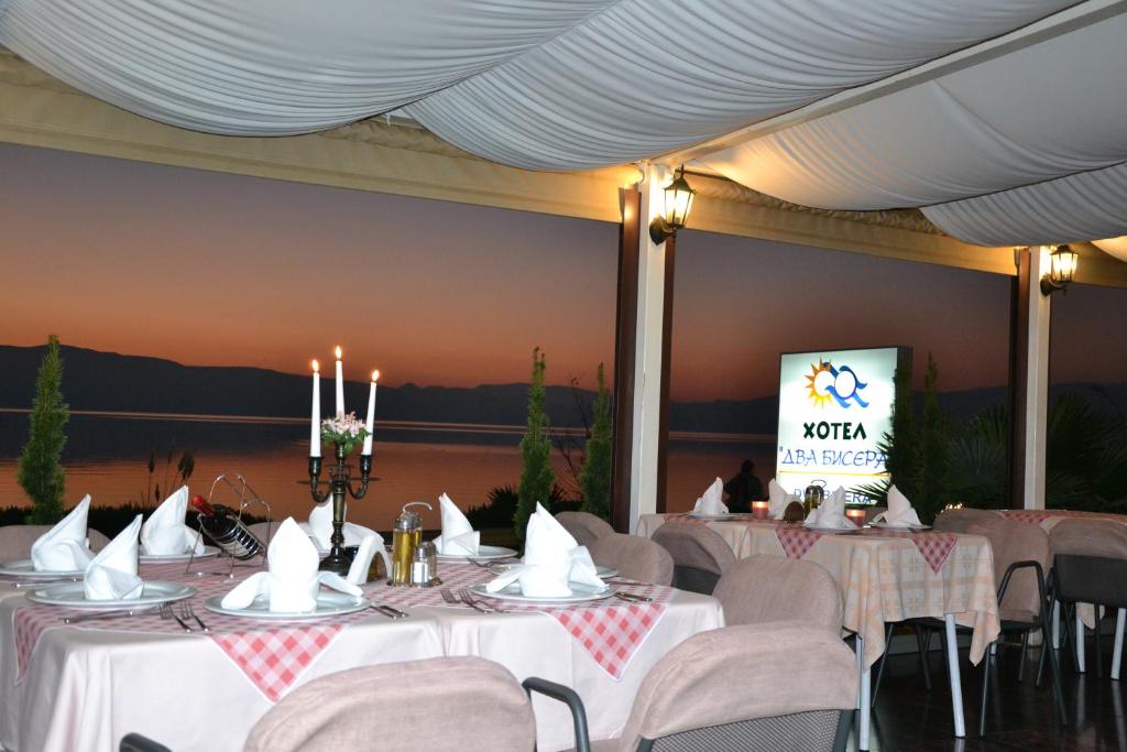 a room with tables and chairs and a screen at Hotel Dva Bisera in Ohrid