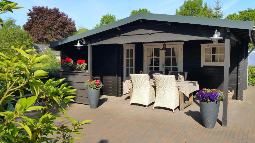 einen schwarzen Pavillon mit Stühlen und einem Tisch in der Unterkunft Bed en Breakfast Gees in Gees