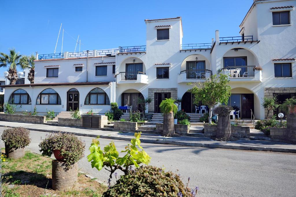 ein großes weißes Gebäude an der Straßenseite in der Unterkunft Follow The Sun Hotel Apartments in Polis Chrysochous