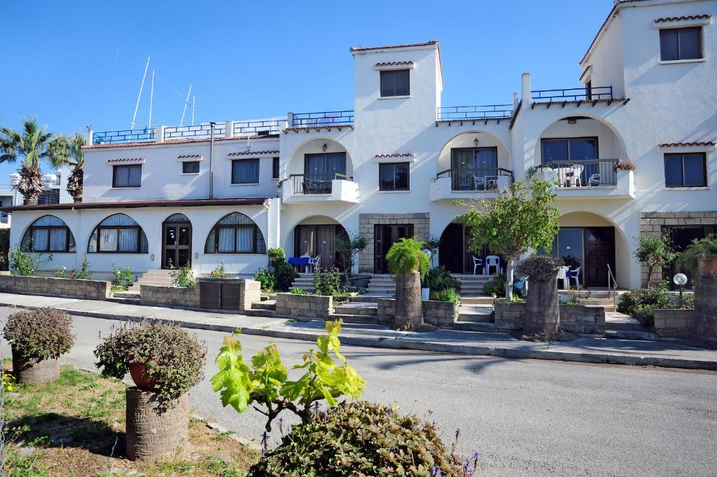 a large white building on the side of a street at Follow The Sun Hotel Apartments in Polis Chrysochous