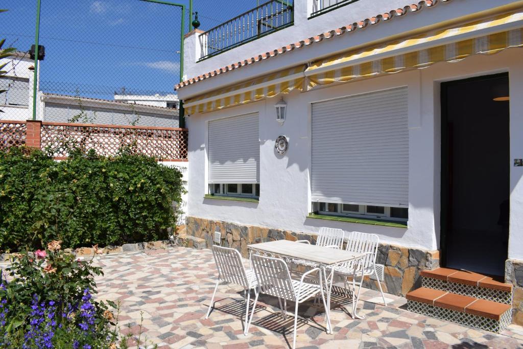 a patio with a table and chairs in front of a house at El Jardin BeNerja in Nerja