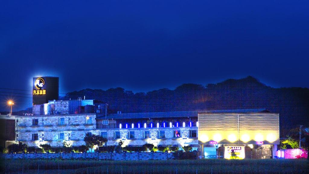 a lit up building with a sign on it at night at Yue Xin Motel in Miaoli