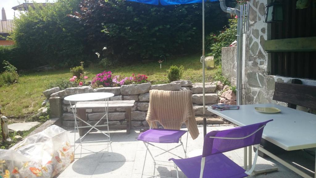 een patio met paarse stoelen, een tafel en een parasol bij Salzachblick in Oberndorf bei Salzburg