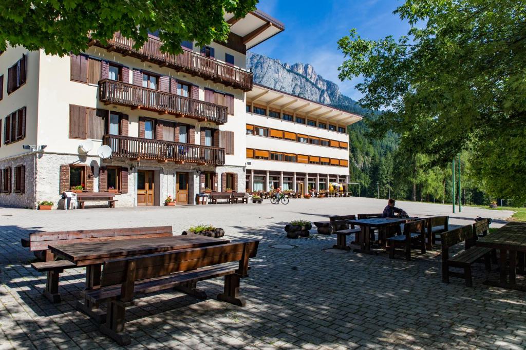 a building with tables and benches in a courtyard at La Gregoriana in Auronzo di Cadore
