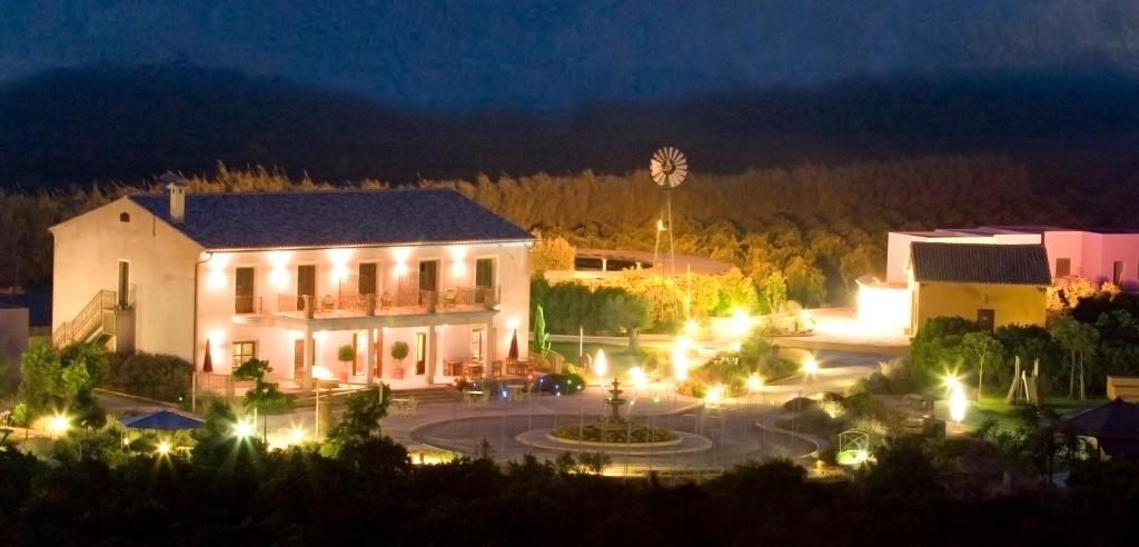 a large white building with a courtyard at night at Hotel Restaurante Font Salada in Oliva