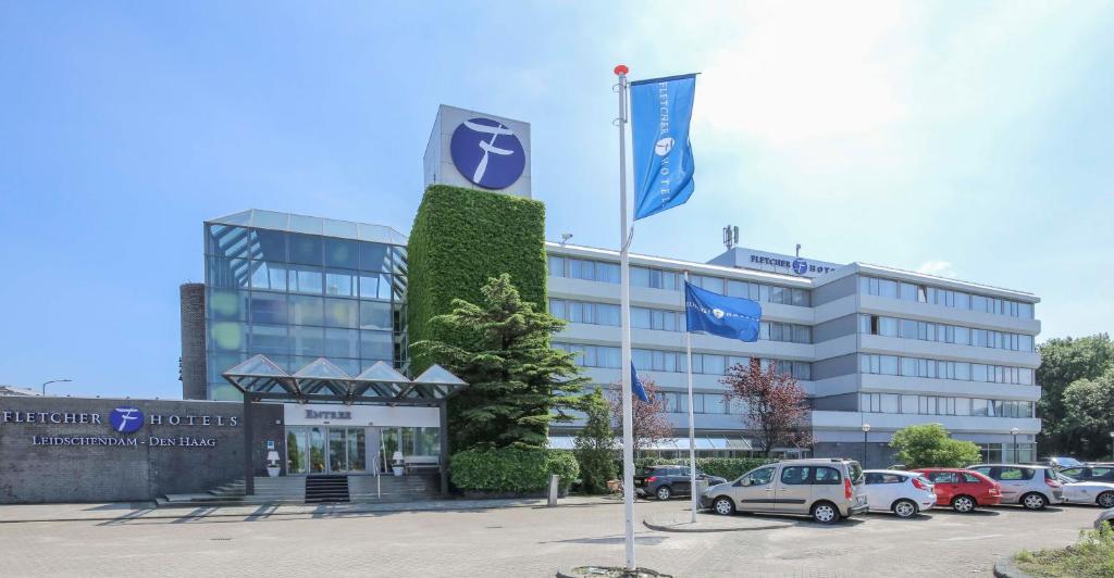 ein Gebäude mit Autos auf einem Parkplatz in der Unterkunft Fletcher Hotel-Restaurant Leidschendam – Den Haag in Leidschendam