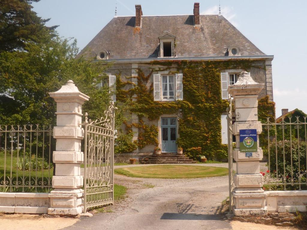 una puerta a una vieja casa con hiedra en Le Logis, en Les Pineaux