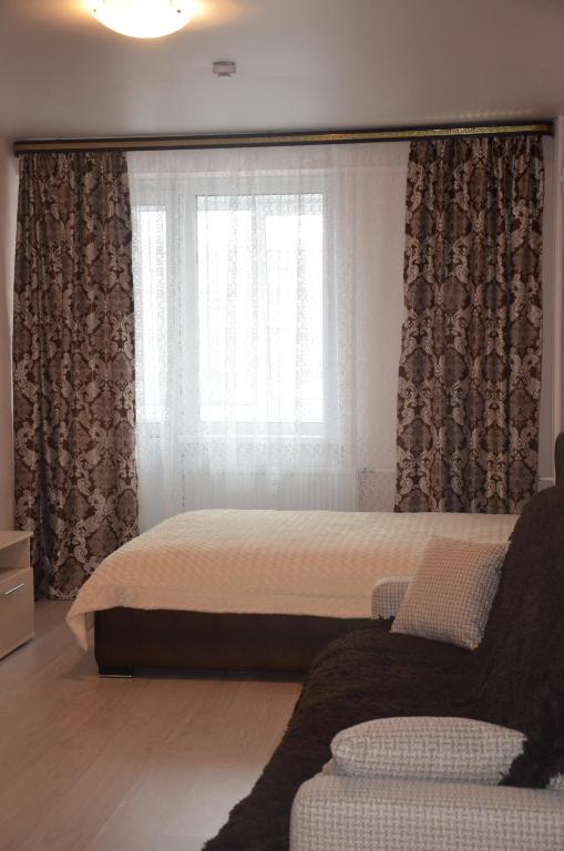 ヴォログダにあるApartment on Marshala Koneva 26のベッドルーム1室(ベッド1台付)、窓(ソファ付)