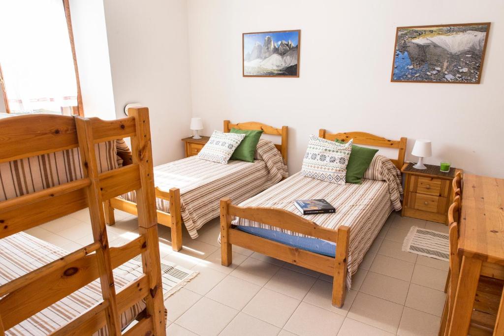 アウロンツォ・ディ・カドーレにあるLa Gregorianaのベッド2台と二段ベッド1組が備わる客室です。