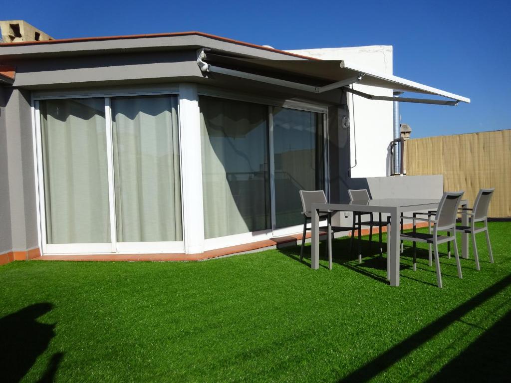 a patio with a table and chairs on grass at Fisa Rentals Shopping in Barcelona