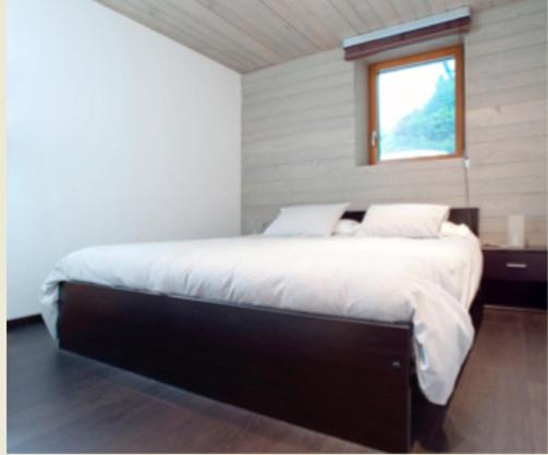 1 dormitorio con 1 cama grande y ventana en Casa al Lido, en Locarno