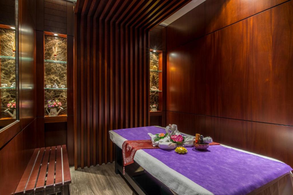 a dining room with a purple table and a bench at Metropolitan Al Mafraq Hotel in Abu Dhabi