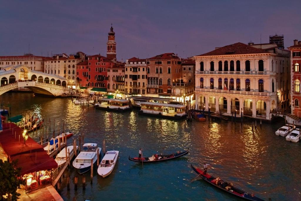 un grupo de barcos en un río en una ciudad en Antica Locanda Sturion Residenza d'Epoca, en Venecia