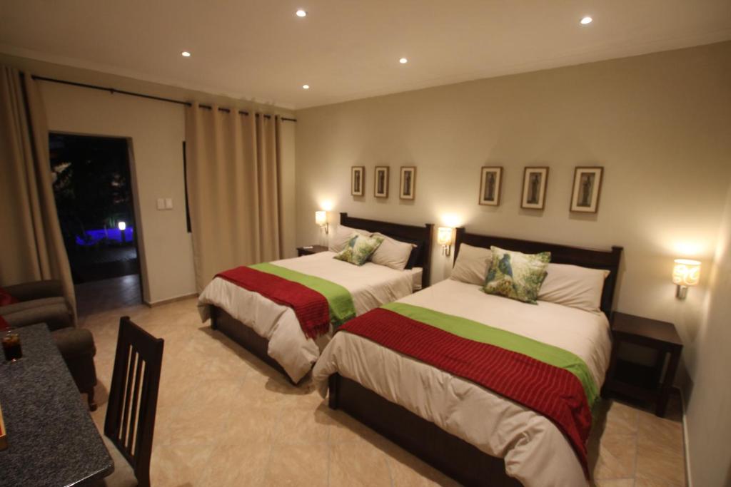 Habitación de hotel con 2 camas y mesa en Forest Villa's, en St Lucia
