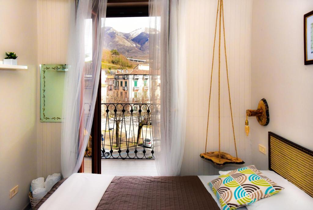 Schlafzimmer mit einem Bett und Blick auf einen Balkon in der Unterkunft Pensione Oliva in Lagonegro