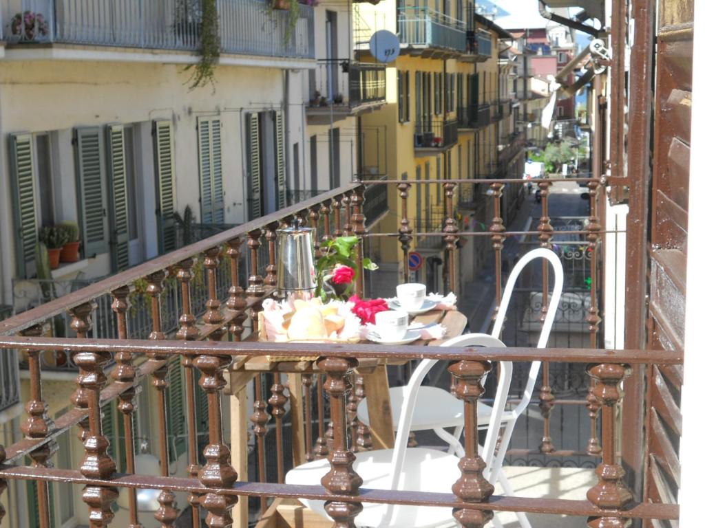 un tavolo e sedie su un balcone di un edificio di Appartamento Giuliano - Stresa a Stresa