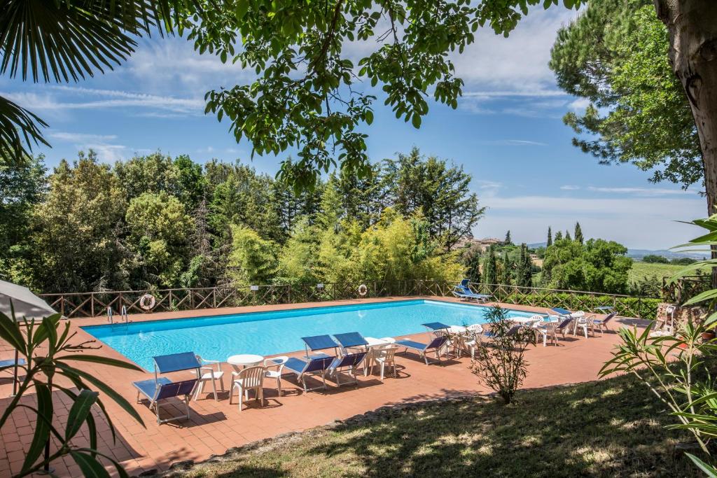 uma piscina com um monte de cadeiras em Castel Pietraio em Monteriggioni
