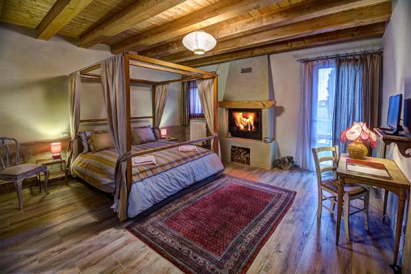 a bedroom with a canopy bed and a fireplace at B&B Corte Vignazza in Rovigo