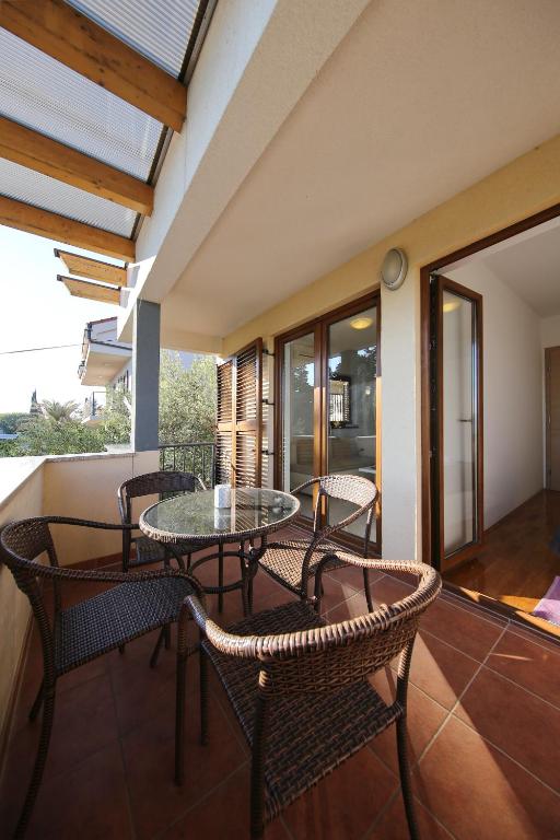 a room with a table and chairs and a balcony at Be-Bu-Mar Apartments in Sveti Filip i Jakov