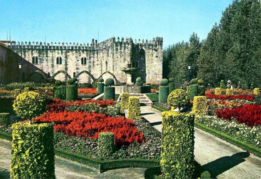 un giardino fiorito di fronte a un castello di Dans L'Atelier Hostel Unidade Porta Nova a Braga