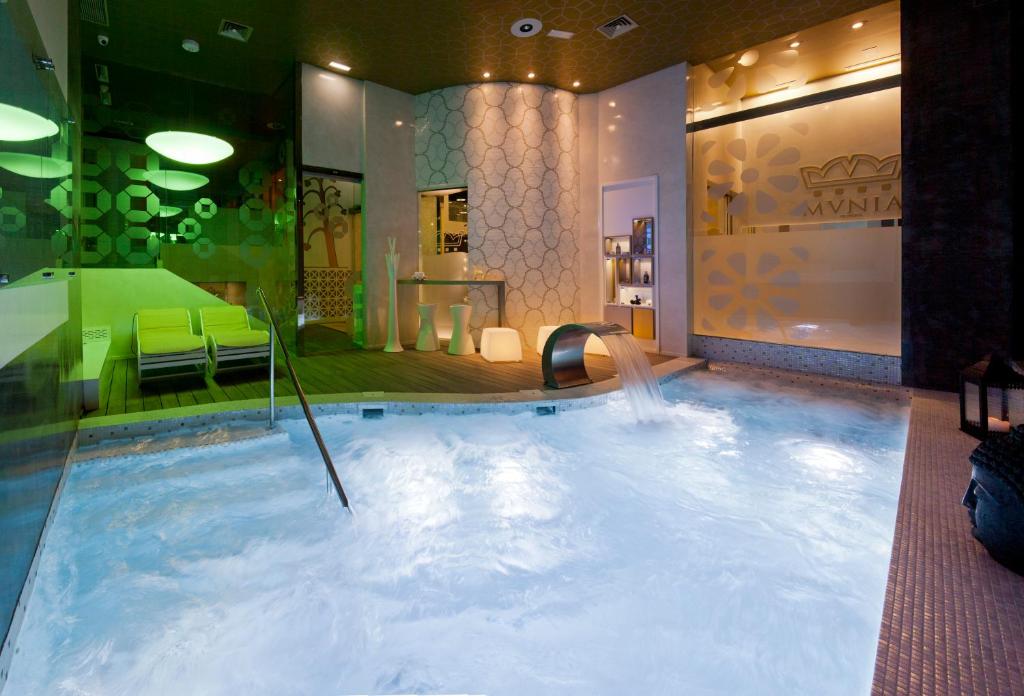 オビエドにあるHotel & Spa Princesa Muniaのホテルの客室内にウォータースライド付きの大きなプールがあります。