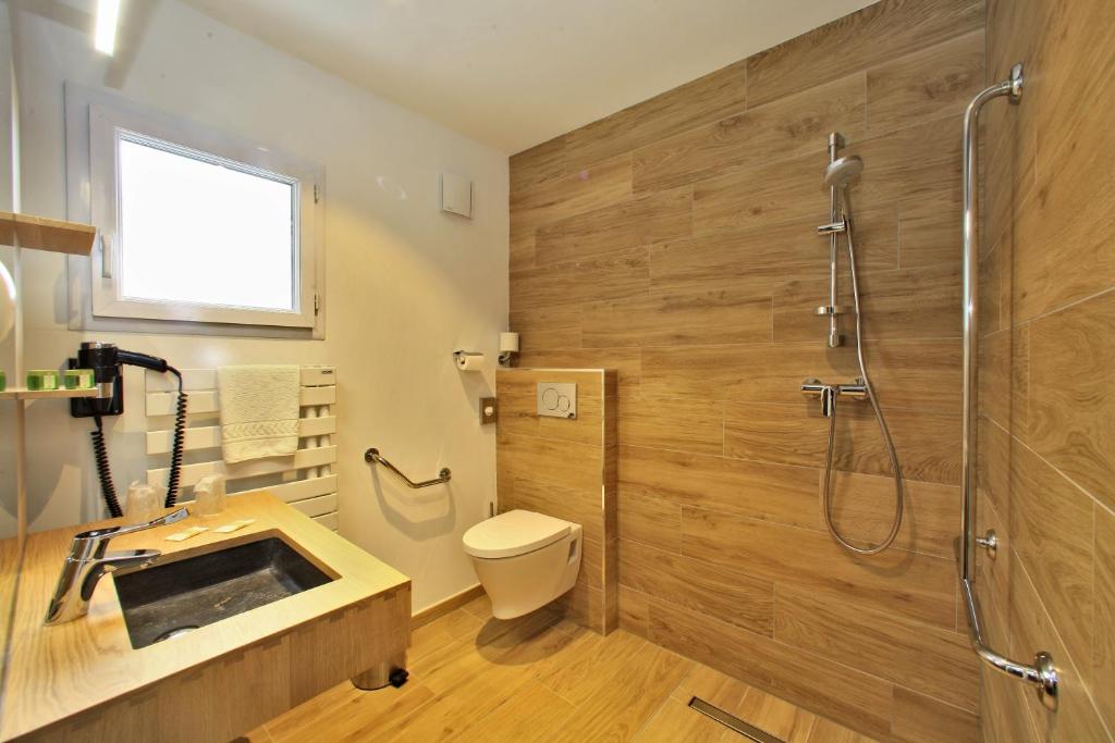 a bathroom with a shower and a toilet and a sink at Logis Hôtel La Chaize in Noirmoutier-en-l'lle