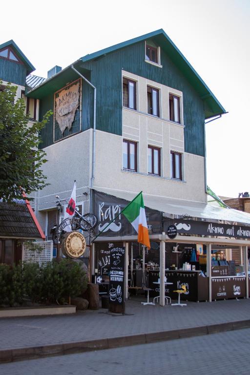 a building with a store front with flags in front of it at Akmuo Ant Akmens in Šventoji