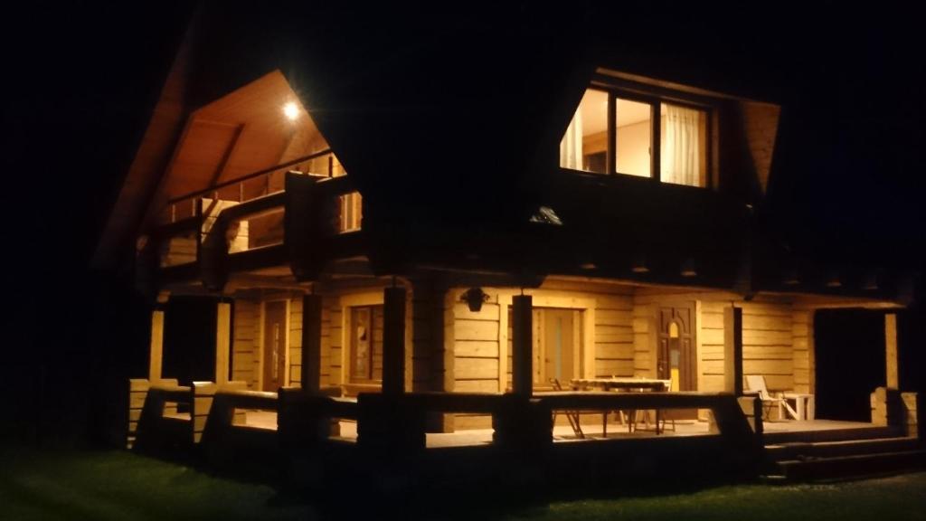 ein Haus in der Nacht mit einem Tisch davor in der Unterkunft Guest house Saulainie krasti in Saulkrasti