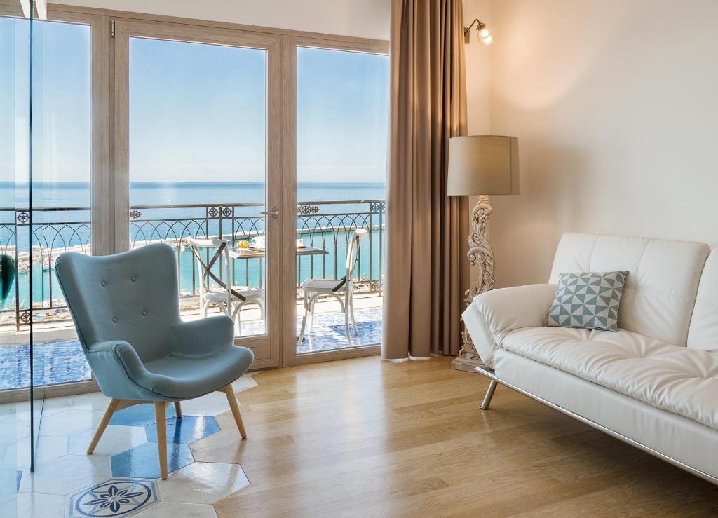 een woonkamer met een bank en uitzicht op de oceaan bij Domus Maris Relais Boutique Hotel in Sciacca