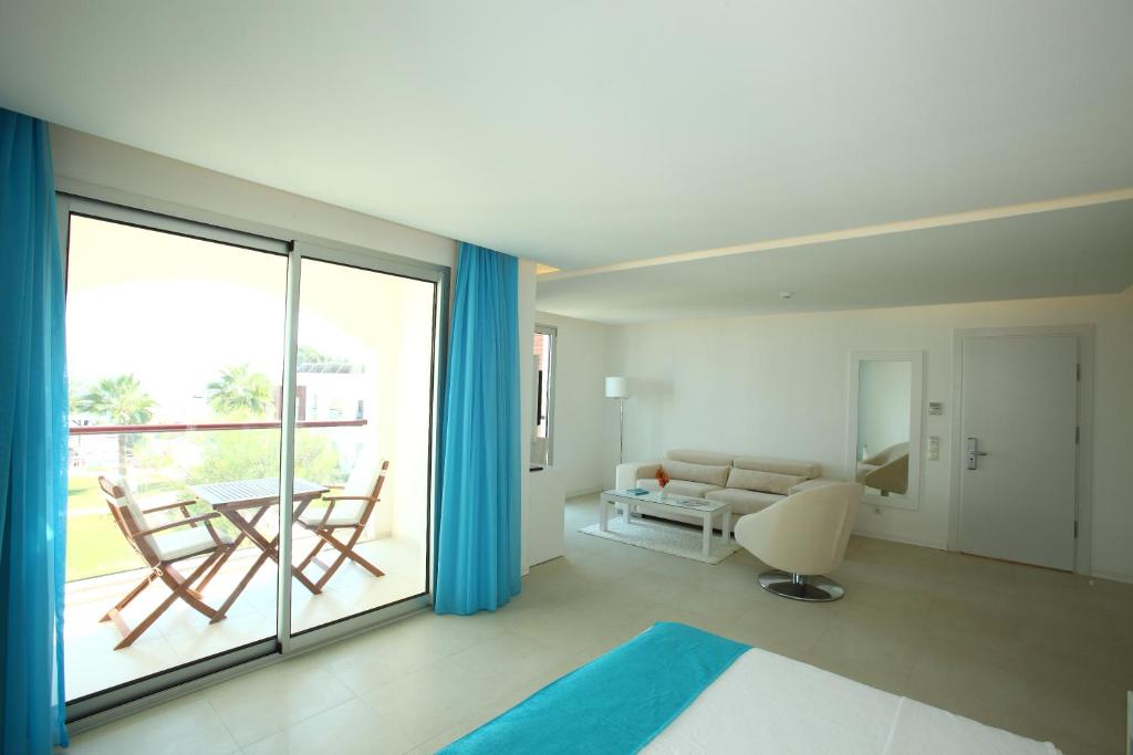 a room with a bed and a couch and a table at Costa Luvi Hotel Bodrum - All Inclusive in Gümbet