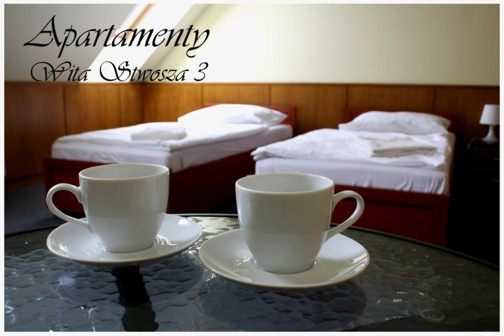 two cups on a table in a room with two beds at Hostel 36 in Katowice