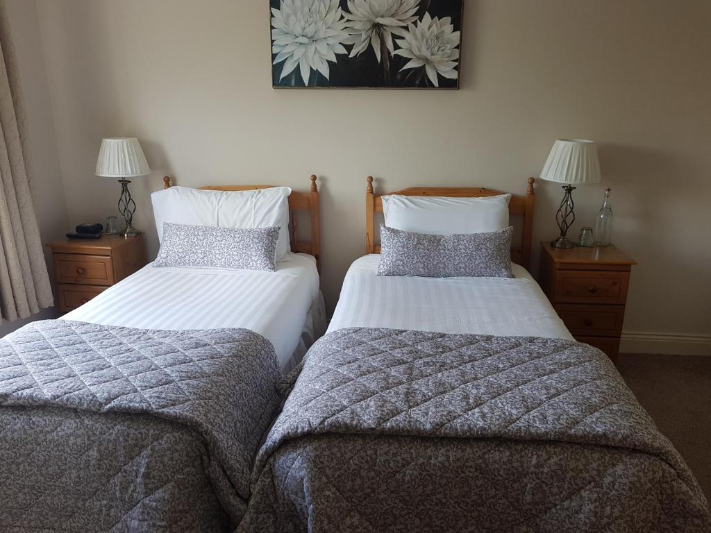 Postel nebo postele na pokoji v ubytování Greenlawn Lodge