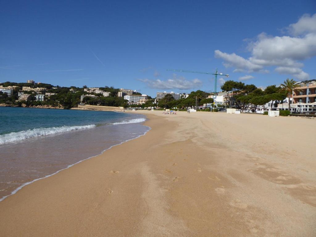 una spiaggia con impronte di piedi nella sabbia e nell'acqua di Apartamento Playa a S'Agaró