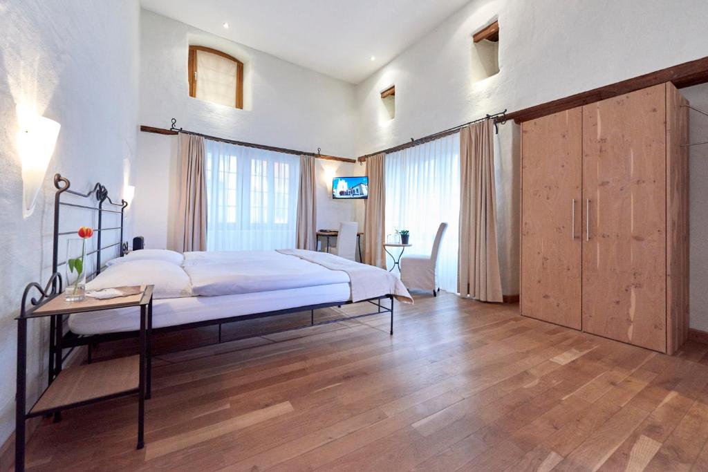 Schlafzimmer mit einem Bett und Holzboden in der Unterkunft Hotel Restaurant Rathaus in Thun