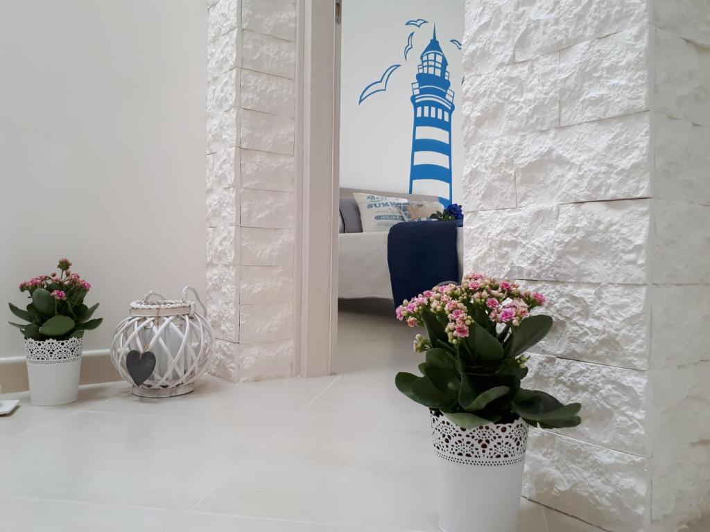 una camera con due piante in vaso e una camera da letto di Dimora Acquamarina a Polignano a Mare