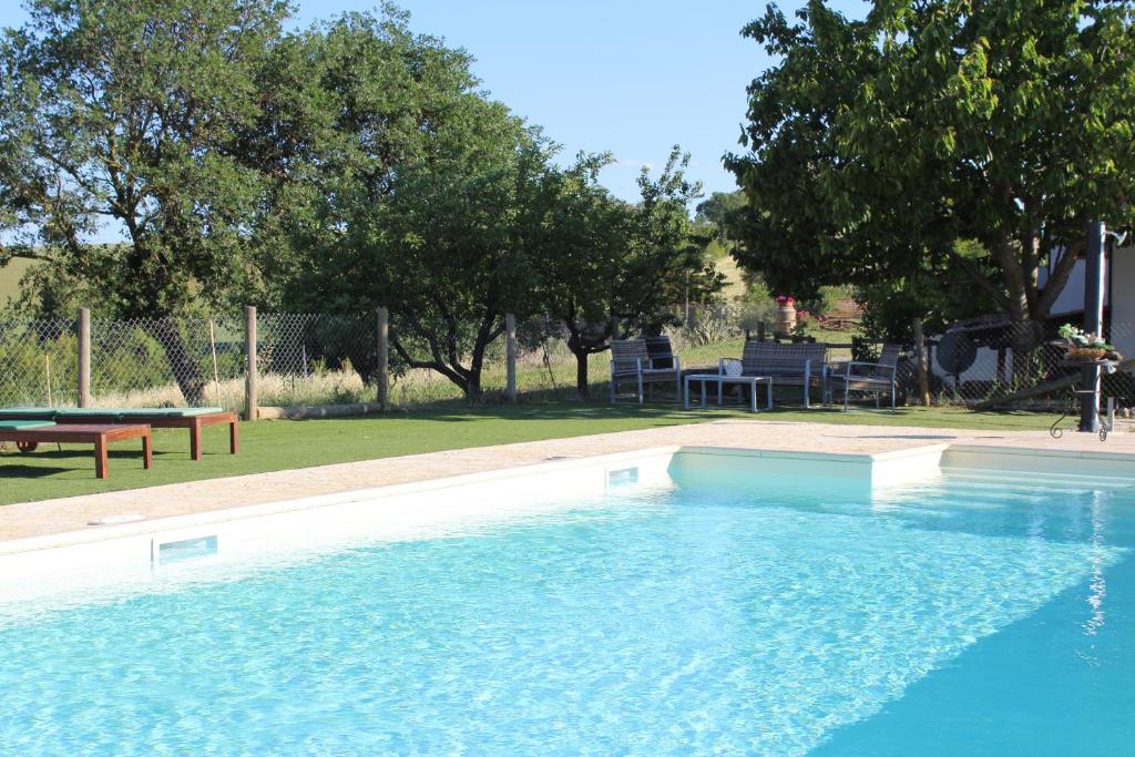 a large swimming pool with a picnic table and trees at Agriturismo I Casamenti in Istia dʼOmbrone