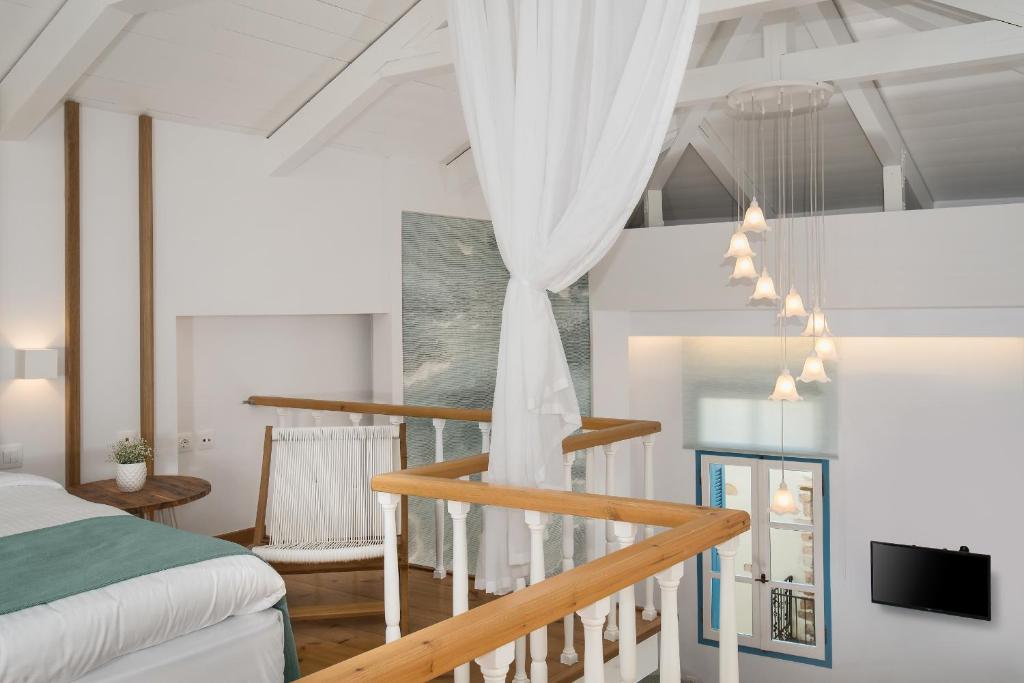 a bedroom with a staircase with a bed and a tv at Aeria Apartments in Chania Town