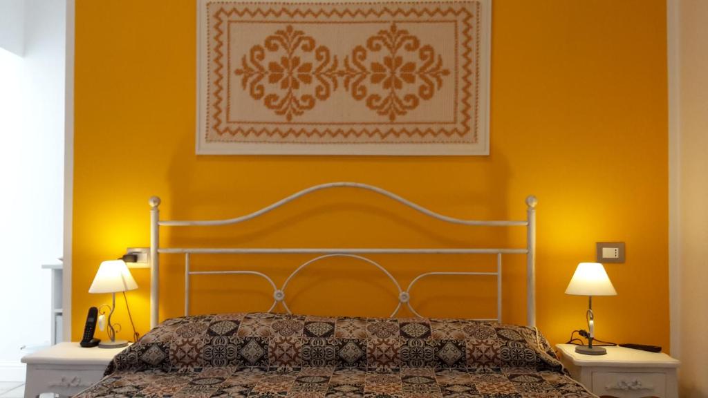 una camera con un letto e una parete gialla di Sa Ramadura a Pula
