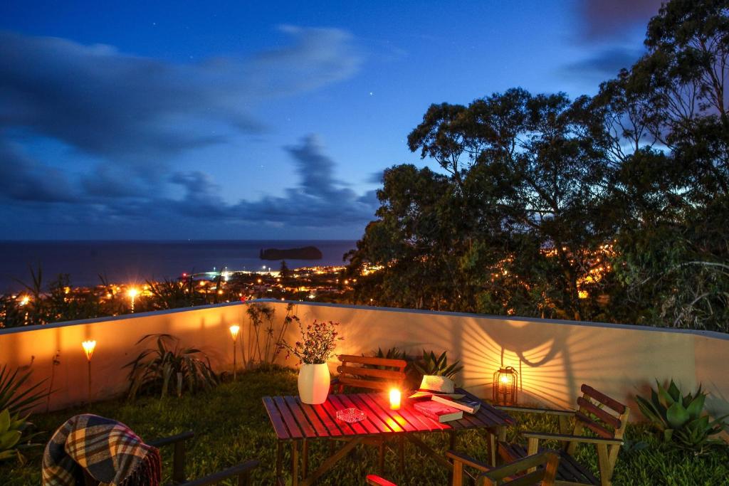 a table and chairs on a patio at night at Place of Moments Natur-Suites SPA in Vila Franca do Campo