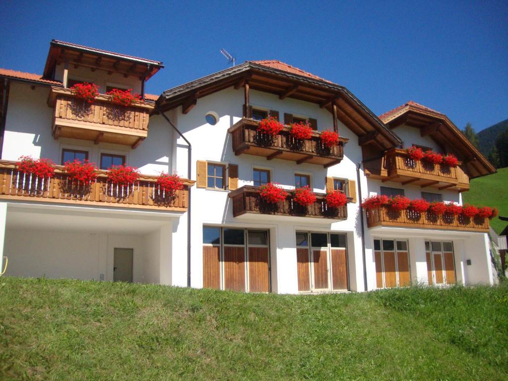 duży biały budynek z czerwonymi kwiatami na balkonach w obiekcie Thalerhof w mieście Percha