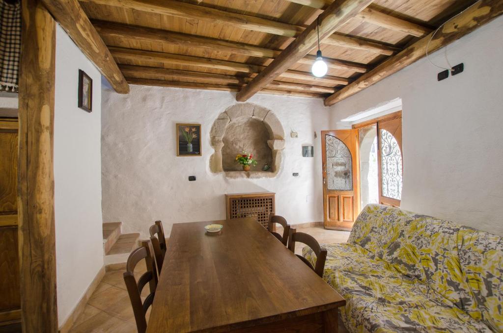 a living room with a wooden table and a couch at Forza d'Agrò Holiday Home in Forza dʼAgro