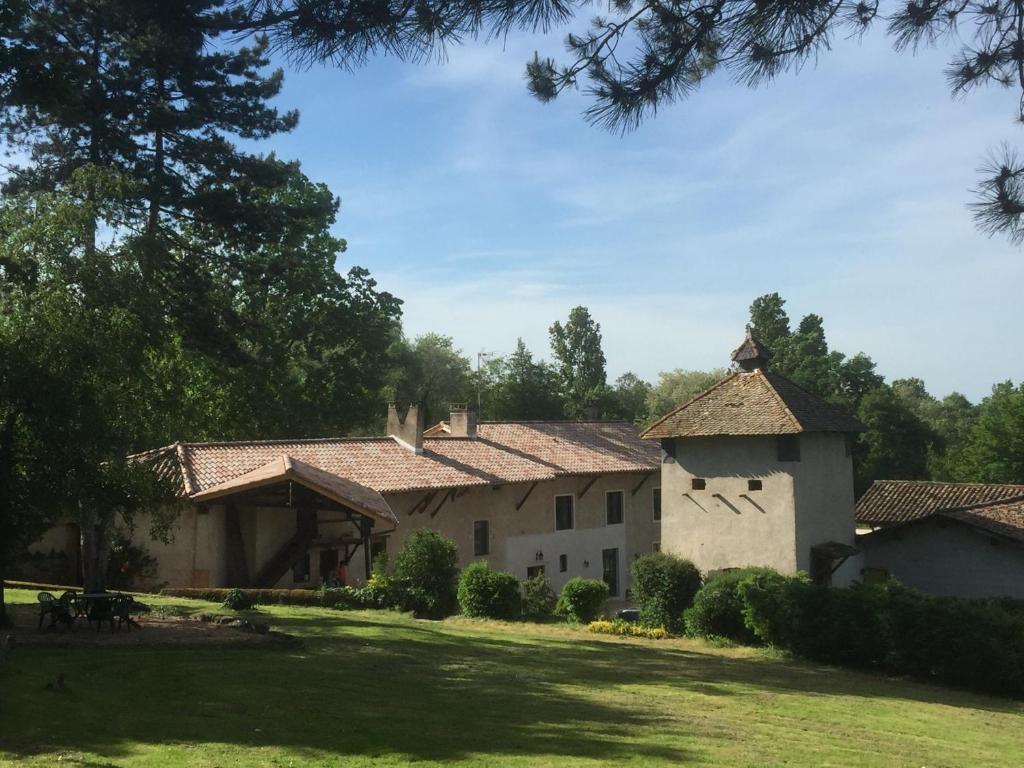 un gran edificio con césped y árboles en Le Moulin de Saint-Julien, en Saint-Didier-sur-Chalaronne