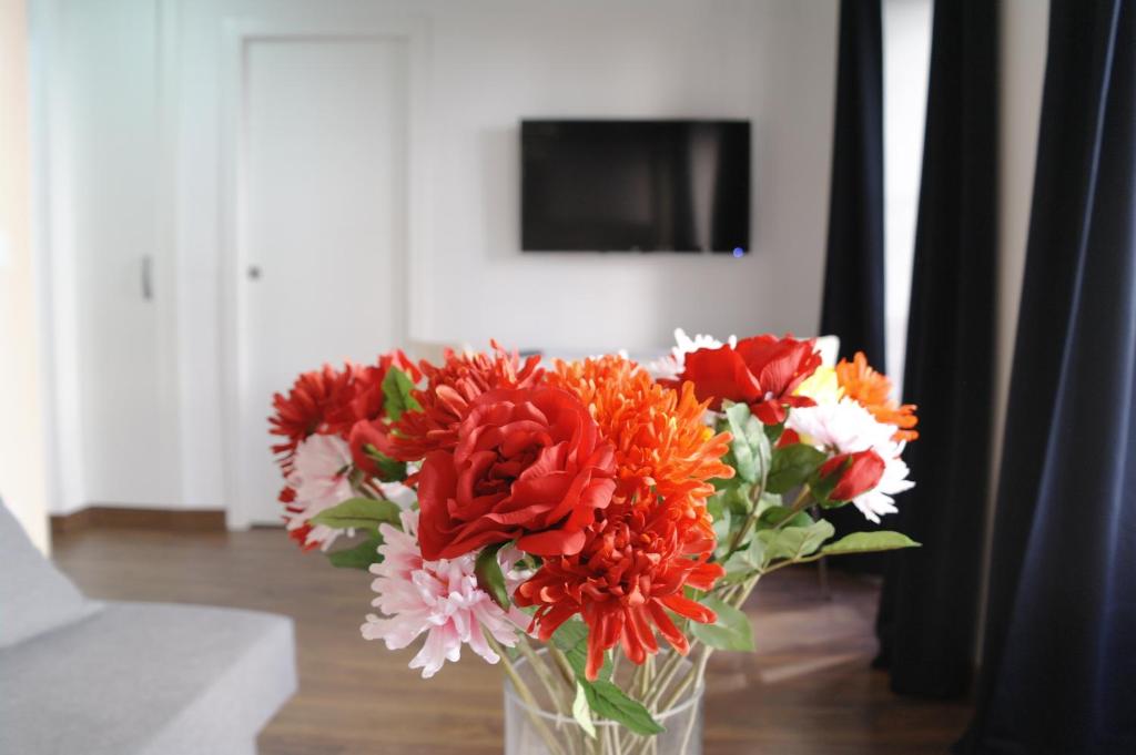 バレンシアにあるUp Townのテーブルの上に赤と白の花を飾った花瓶