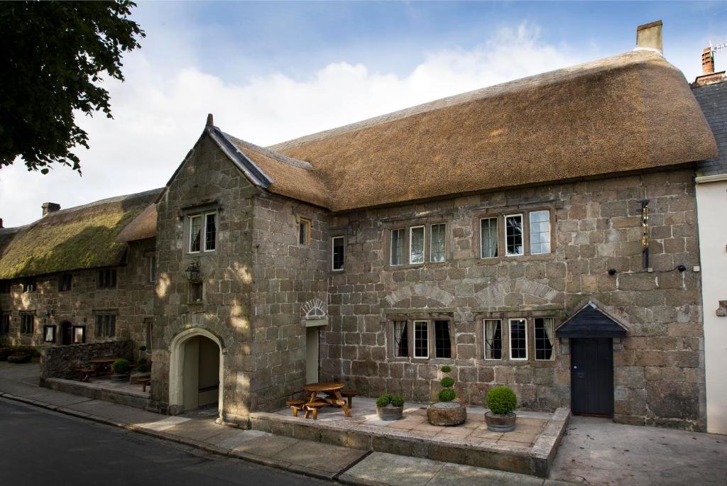 an old stone building with a thatched roof at The Three Crowns in Chagford